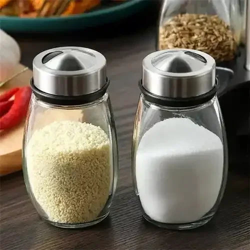 Potes de vidro para temperos com tampas de inox em bancada de cozinha