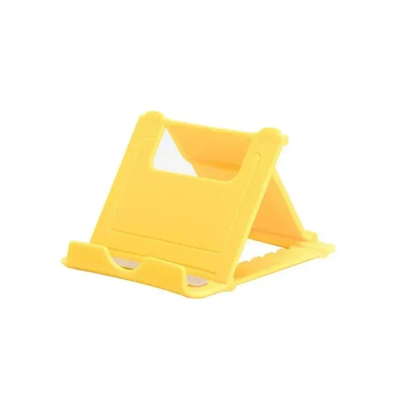 Suporte dobrável amarelo para celular em plástico, sobre fundo branco.