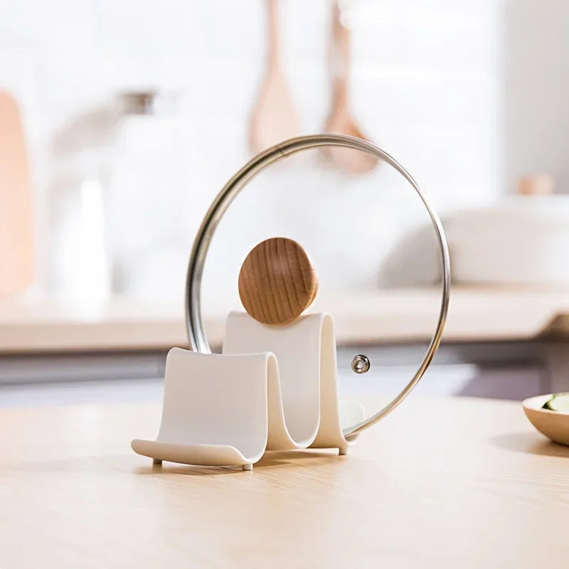 Suporte branco para tampa de panela e colher em cozinha moderna com bancada de madeira.