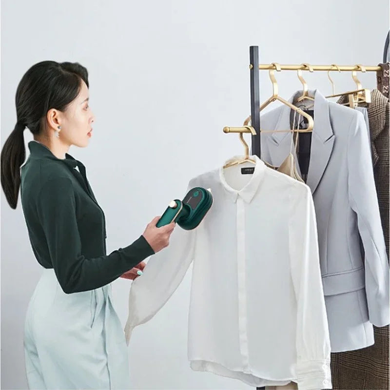 Mulher usando vaporizador portátil de roupas em camisa branca em cabideiro moderno.