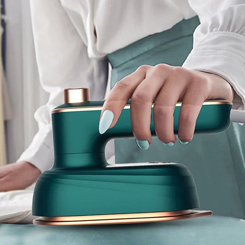 Mulher passando roupa com ferro a vapor portátil verde em superfície plana