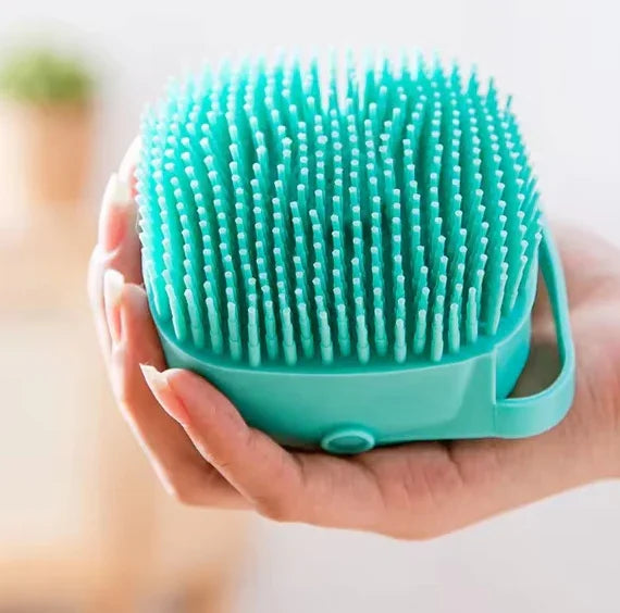 Esponja de silicone verde para banho com cerdas, acessório de higiene, mão segurando.