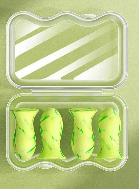 Quatro protetores auriculares verdes em estojo transparente sobre fundo verde