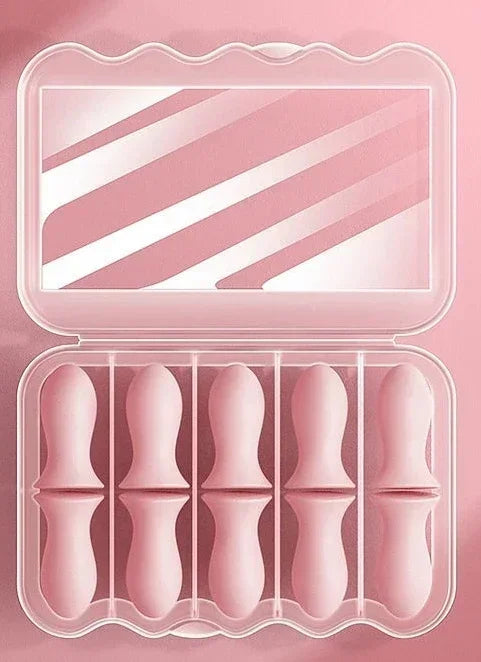 Estojo rosa com cinco protetores de silicone para dedos, em fundo cor-de-rosa.