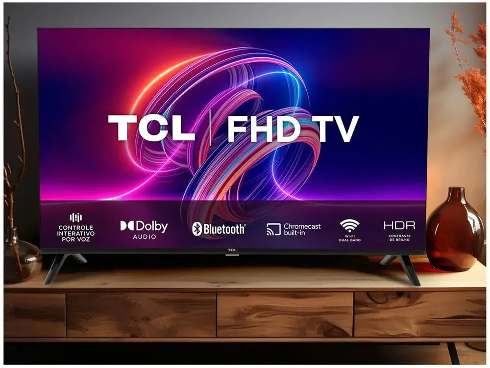 Smart TV TCL FHD em mesa de madeira, tela ligada com funções Dolby Audio, Bluetooth, HDR e Chromecast integrados
