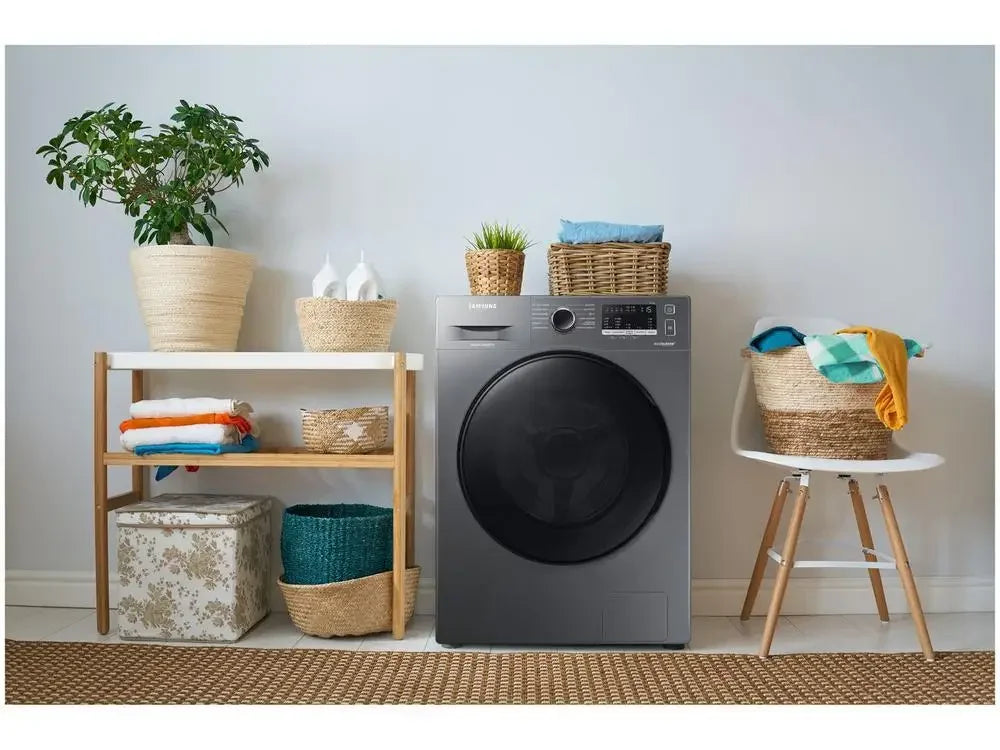 Lavadora Samsung preta em lavanderia moderna com cestos de roupas, plantas e prateleira decorativa