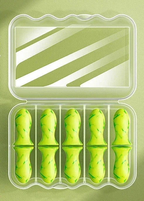 Estojo verde transparente com seis protetores auriculares de espuma verde, organizado em divisórias.